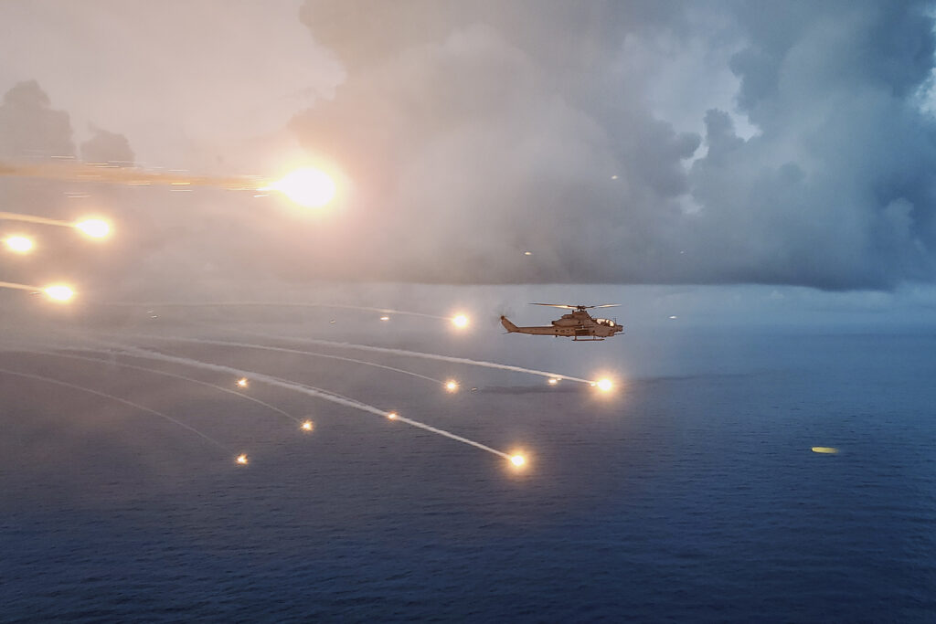 A U.S. Marine Corps AH-1Z Viper attached to Marine Medium Tiltrotor Squadron (VMM) 165 (Reinforced), 15th Marine Expeditionary Unit, dispenses flares while conducting threat counter tactics training over the Pacific Ocean Aug. 1, 2024. The aircraft launched from the amphibious assault ship USS Boxer (LHD 4). Boxer and embarked elements of the 15th MEU are conducting routine operations in the U.S. 7th Fleet areas of operations. 7th Fleet is the U.S. Navy’s largest forward-deployed numbered fleet, and routinely interacts and operates with allies and partners in preserving a free and open Indo-Pacific region. (U.S. Marine Corps photo by Lt. Col. Michael Harper)